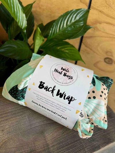 back wrap in it's packaging, fabric is a light minty green, featuring hibiscus flowers in green and a pale apricot contrast with dark green spots.